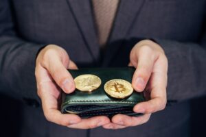 Close-up of businessman with wallet receiving and paying by bitcoin or cryptocurrency