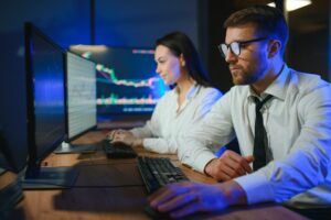 Team of traders working at monitor computer and browsing online in trading office